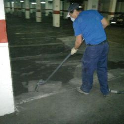 Trabajador realizando limpieza en suelo de garaje