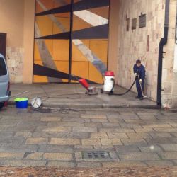 Trabajador con aspirador industrial realizando limpieza de exterior